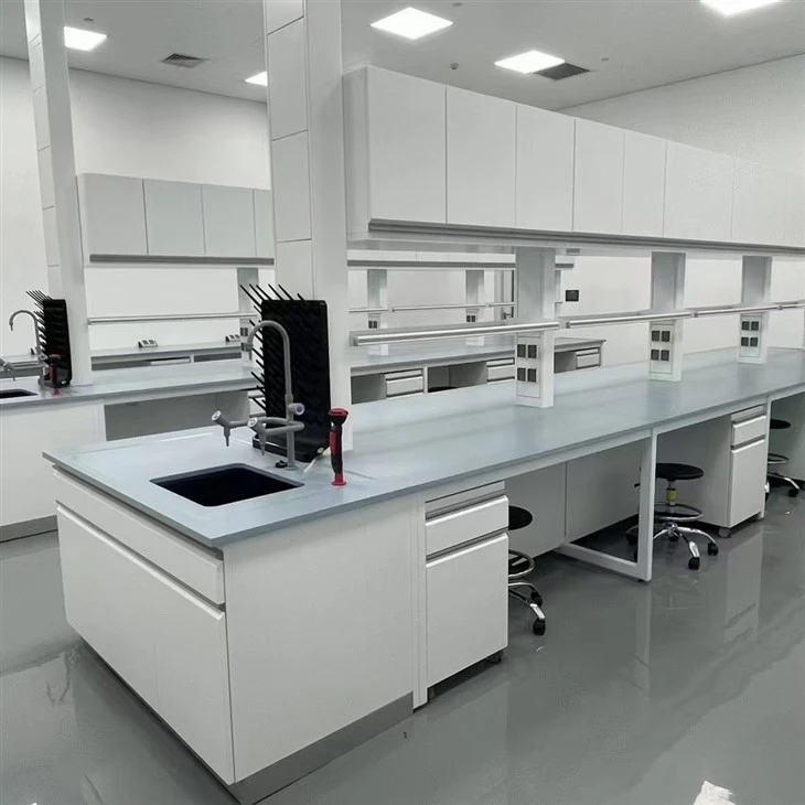 Installed wet laboratory island bench with sink, service columns, reagent shelving and mobile storage