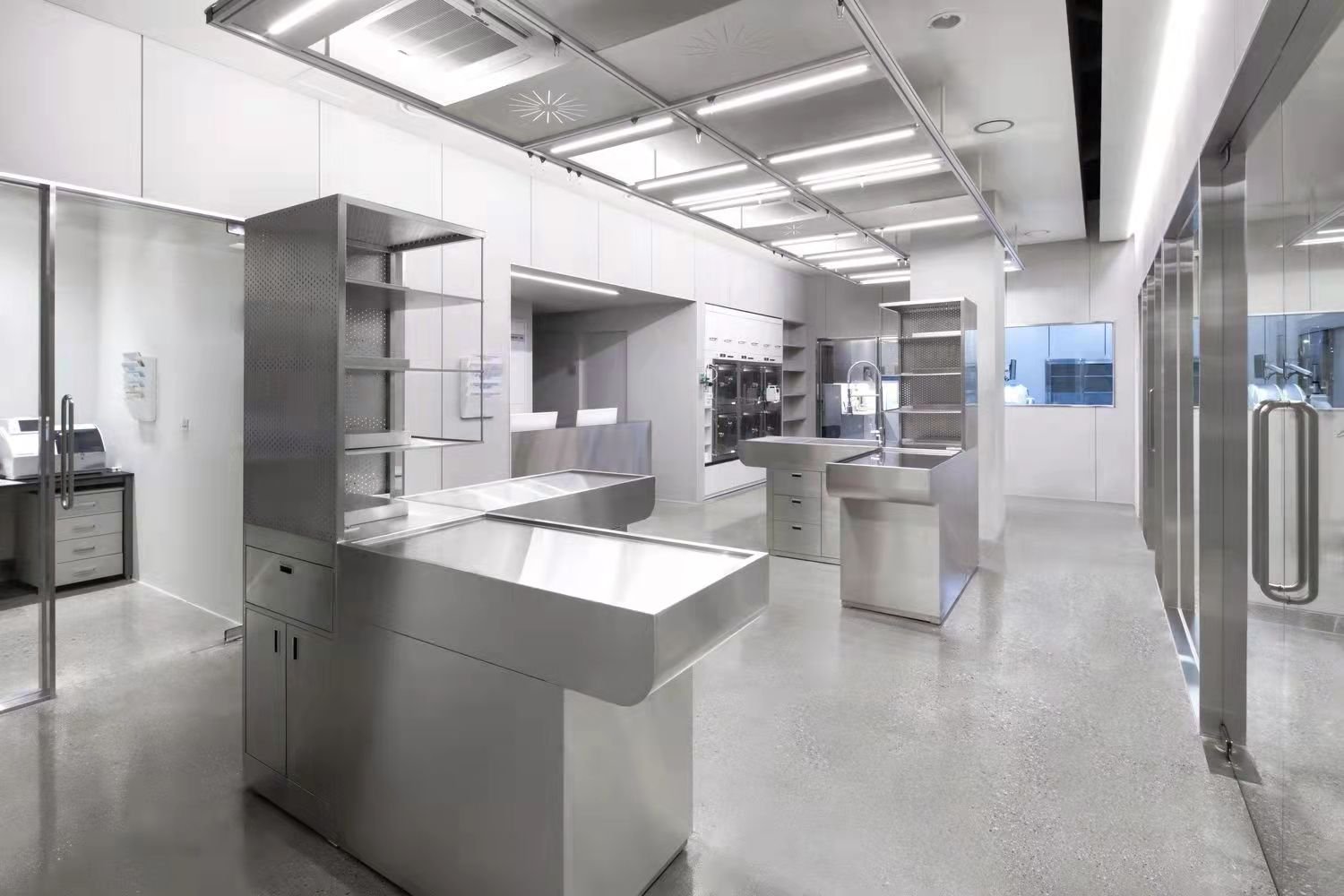 Stainless steel laboratory workstation layout with sinks and open shelving